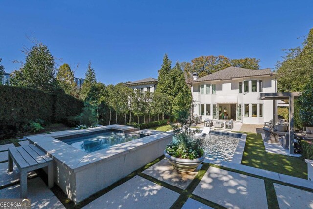 rear view of house featuring an outdoor living space, a lawn, a patio, and a fenced in pool