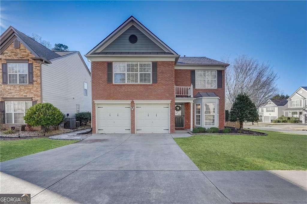 front of property featuring central AC, a garage, and a front yard