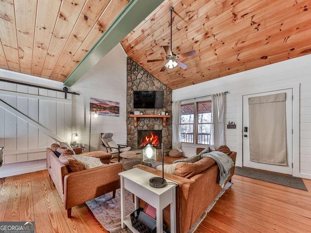 living room with a stone fireplace, wooden ceiling, high vaulted ceiling, and light hardwood / wood-style flooring