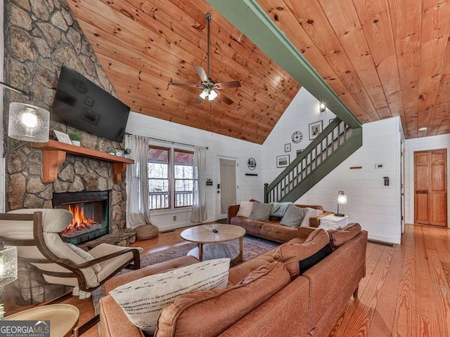 living room featuring high vaulted ceiling, a stone fireplace, wooden ceiling, and light hardwood / wood-style floors