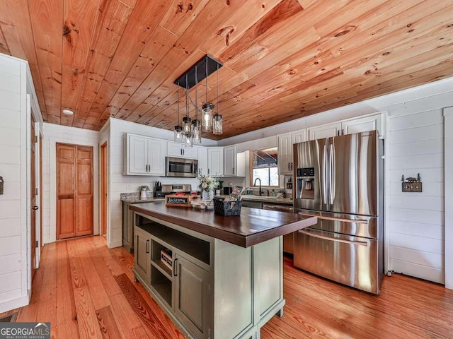 kitchen with white cabinetry, decorative light fixtures, wooden ceiling, and appliances with stainless steel finishes