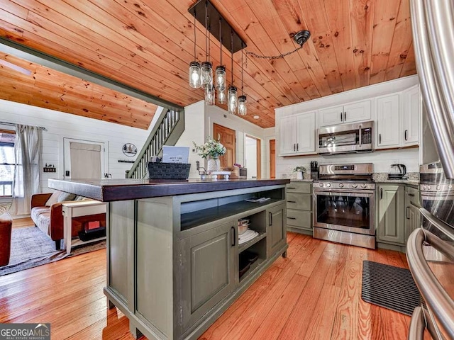 kitchen with stainless steel appliances, hanging light fixtures, white cabinets, and wood ceiling