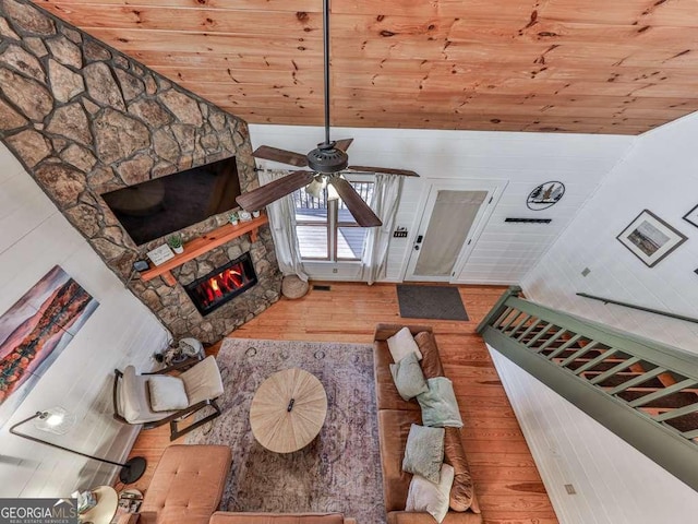 living room with lofted ceiling, wooden ceiling, ceiling fan, a fireplace, and hardwood / wood-style floors