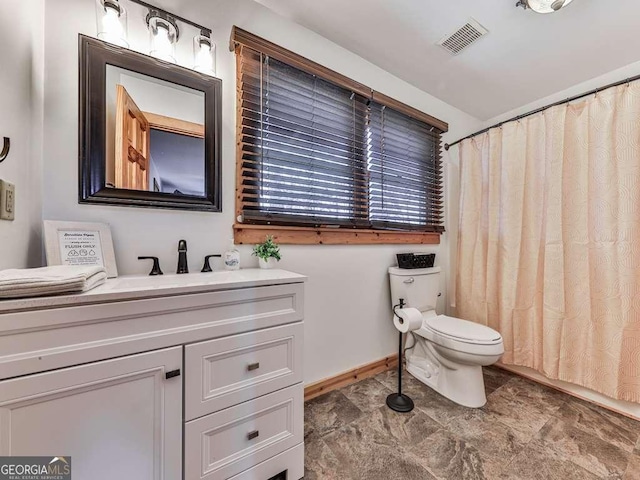 bathroom with vanity, curtained shower, and toilet