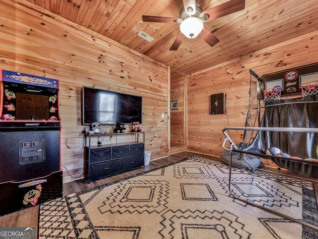 living room with ceiling fan, wood-type flooring, wooden walls, and wooden ceiling