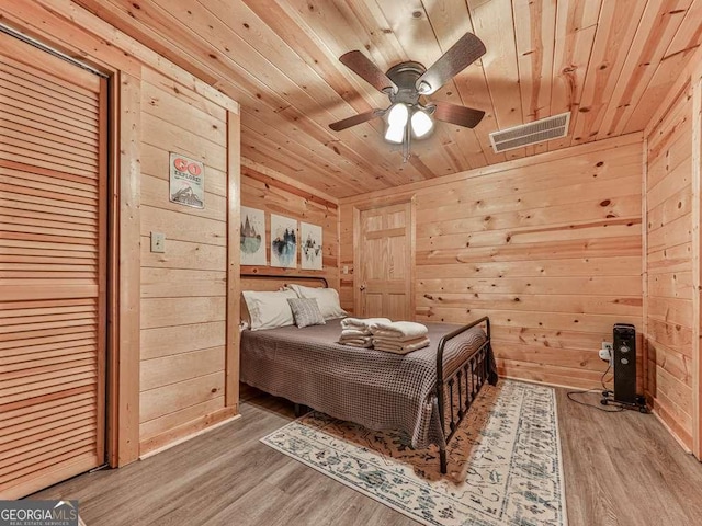 bedroom featuring wood-type flooring, wooden ceiling, and wood walls