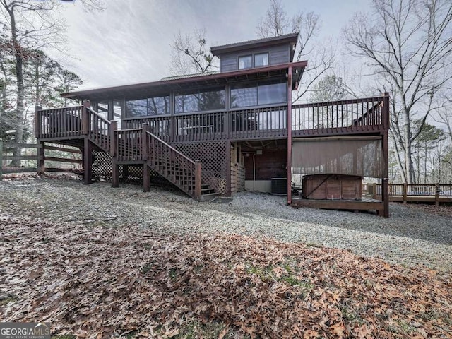 back of house with cooling unit, a jacuzzi, a sunroom, and a deck