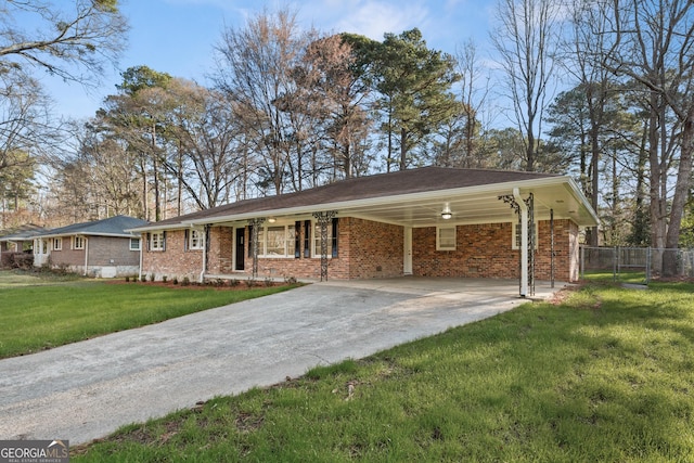 single story home featuring an attached carport, fence, driveway, a front lawn, and brick siding