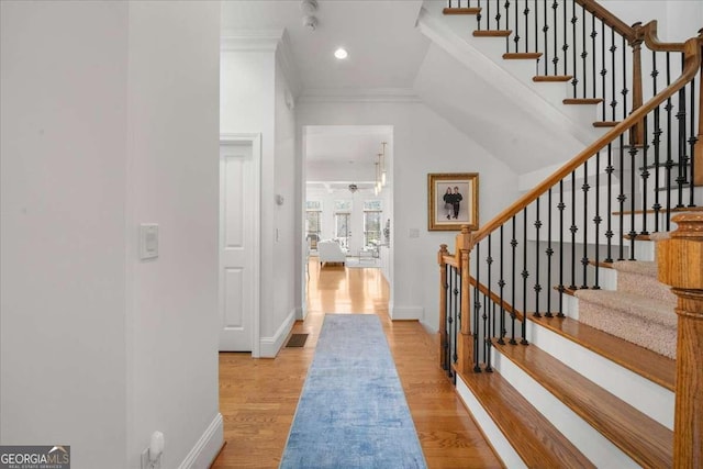 entrance foyer featuring ornamental molding and light hardwood / wood-style floors