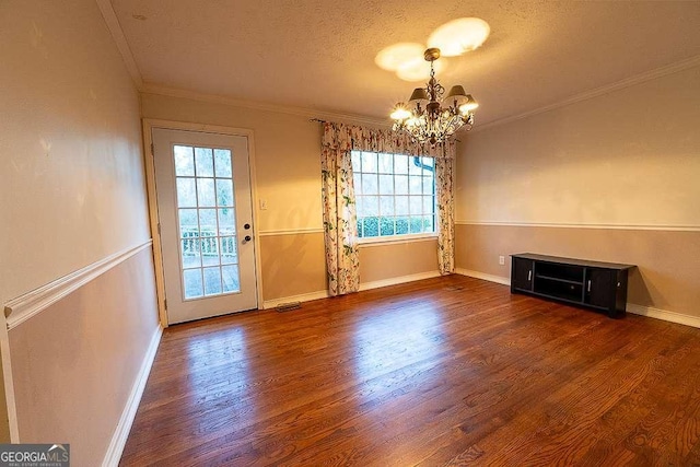 interior space featuring dark hardwood / wood-style flooring, a notable chandelier, crown molding, and plenty of natural light