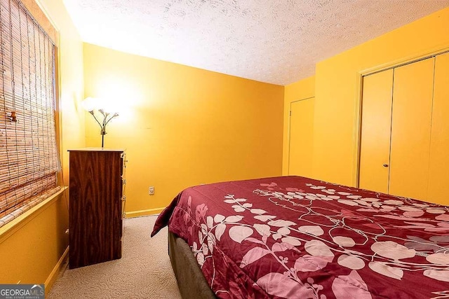 carpeted bedroom featuring a textured ceiling and a closet