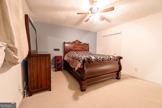 carpeted bedroom featuring a textured ceiling, a closet, and ceiling fan