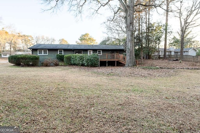 rear view of house with a lawn and a deck