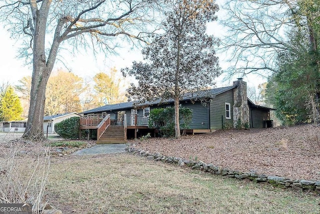 back of property featuring a lawn and a deck