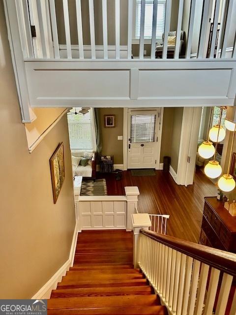 stairs featuring wood-type flooring and a high ceiling