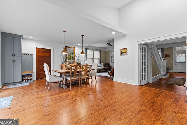 dining room with a towering ceiling, hardwood / wood-style floors, and ceiling fan