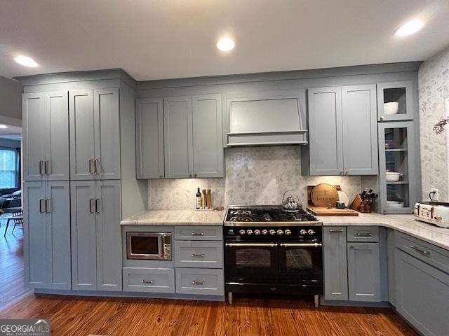 kitchen featuring gray cabinets, double oven range, and premium range hood