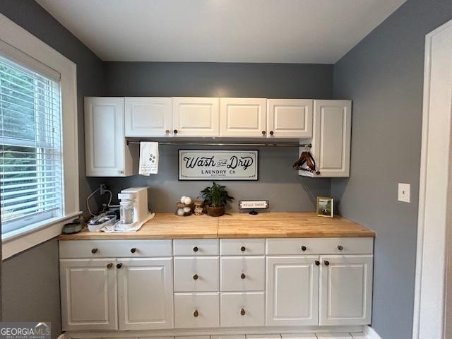 bar with white cabinetry, a wealth of natural light, and wooden counters