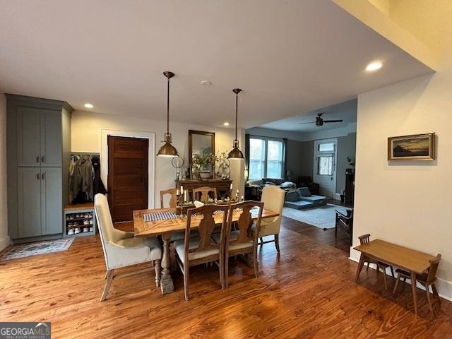 dining space featuring wood-type flooring and ceiling fan