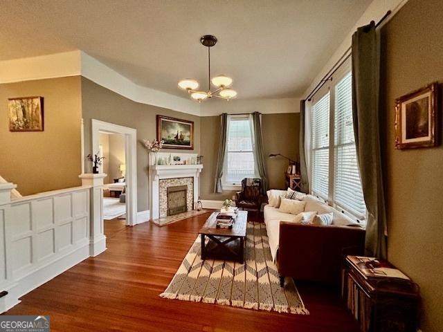 living room with dark hardwood / wood-style flooring and a chandelier