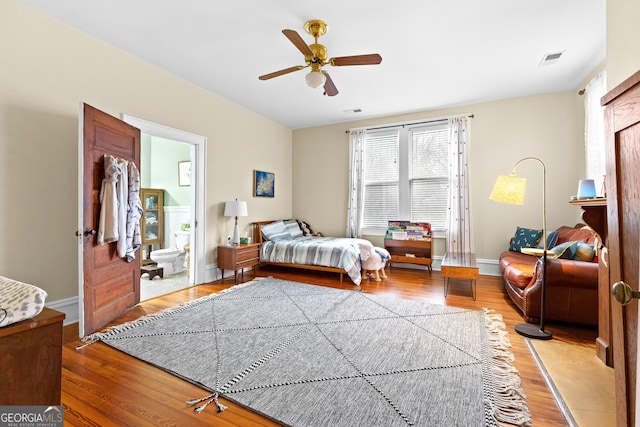 bedroom with ensuite bathroom, ceiling fan, and light wood-type flooring