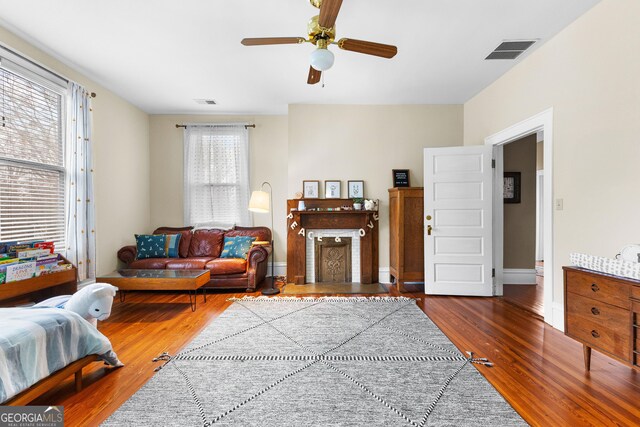 living room with dark wood-type flooring and ceiling fan