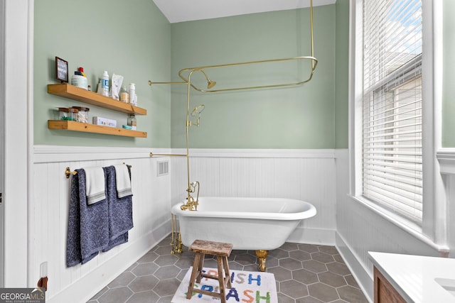 bathroom featuring vanity, a tub, and tile patterned floors