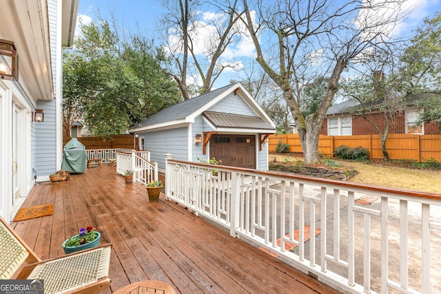 wooden deck with a garage and an outbuilding