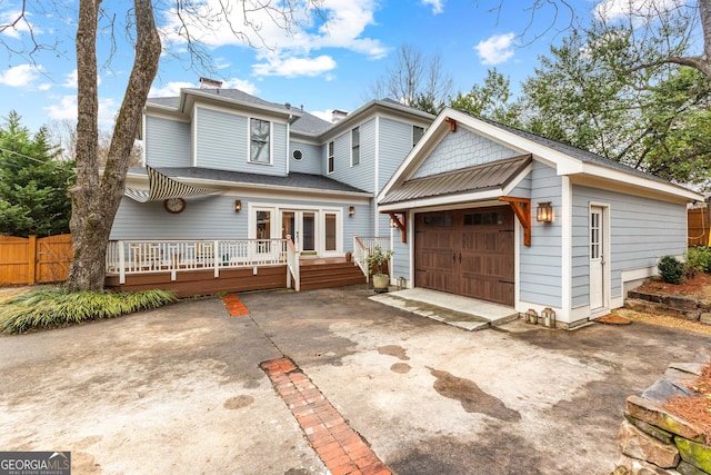 view of property featuring a garage and a wooden deck