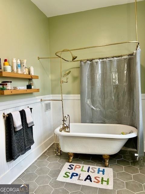 bathroom with a bathing tub and tile patterned floors