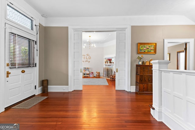 entrance foyer with an inviting chandelier and dark hardwood / wood-style flooring