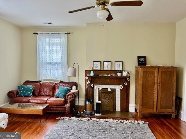 living area featuring dark hardwood / wood-style flooring and ceiling fan