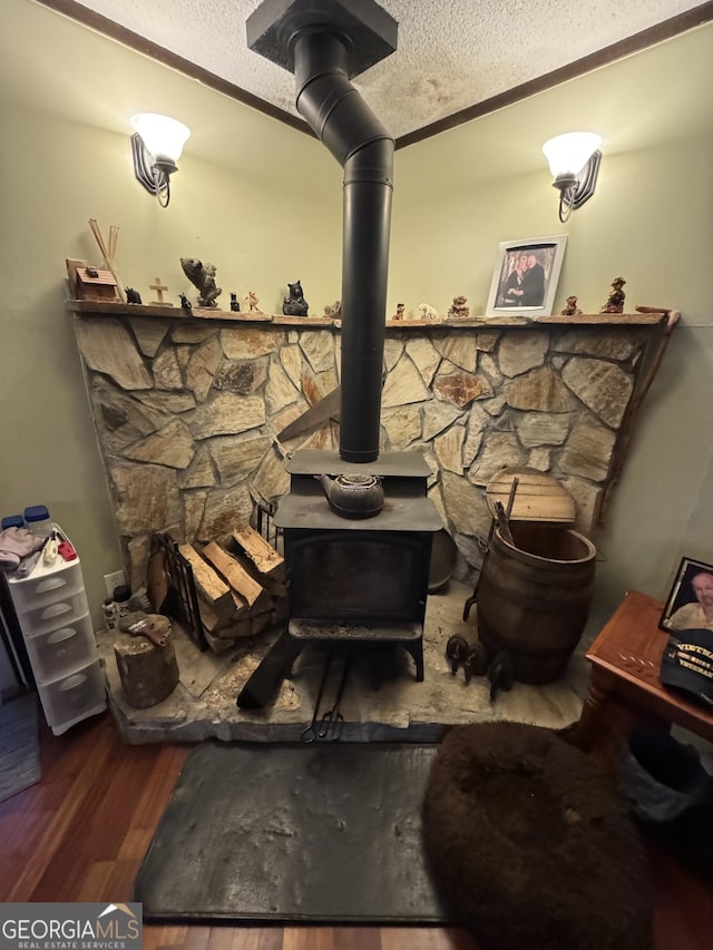 details featuring wood-type flooring, a textured ceiling, and a wood stove