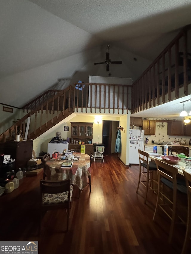 dining space with lofted ceiling, dark hardwood / wood-style floors, a textured ceiling, and ceiling fan