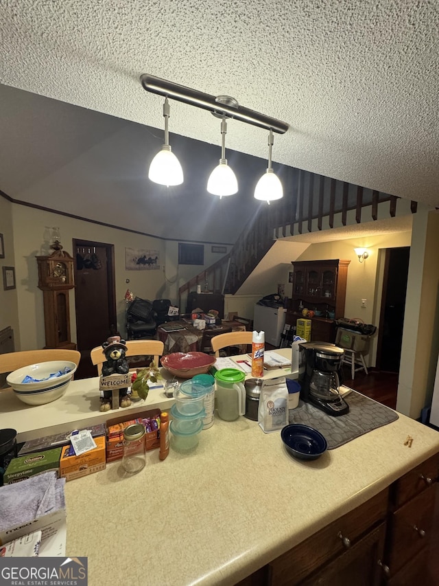 kitchen with pendant lighting, dark brown cabinets, and a textured ceiling