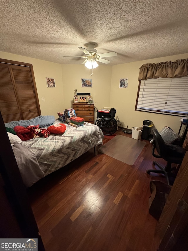 bedroom featuring dark hardwood / wood-style flooring, a textured ceiling, and ceiling fan