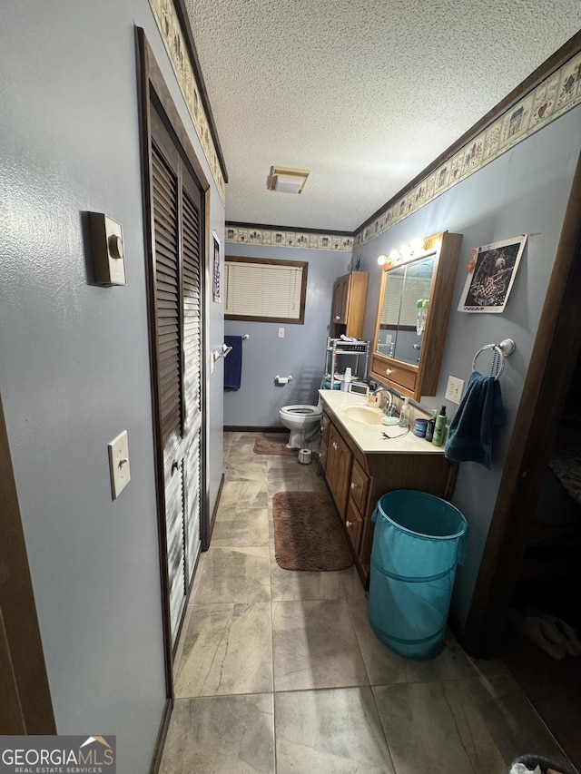 bathroom with vanity, a textured ceiling, and toilet