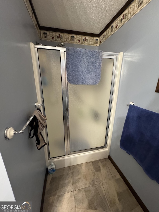 bathroom with a shower with door and a textured ceiling