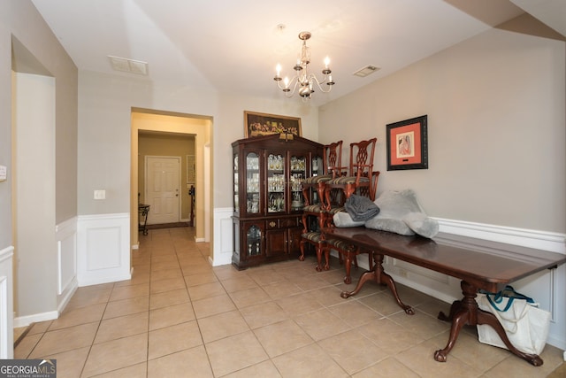 tiled dining space with a chandelier