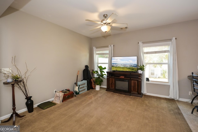 living area with ceiling fan and light carpet