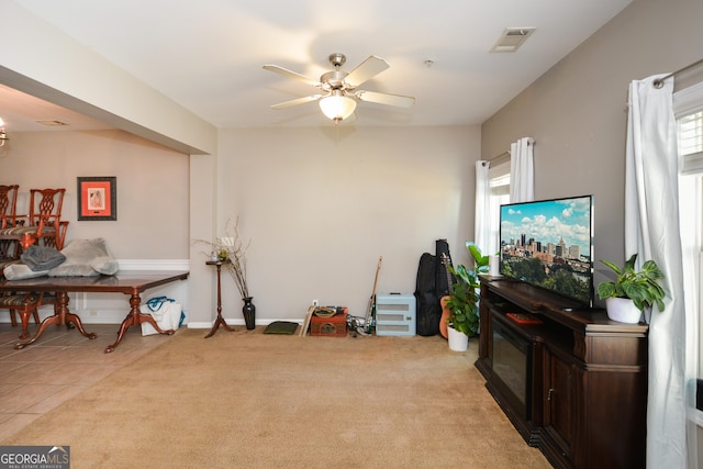 living area featuring light carpet and ceiling fan