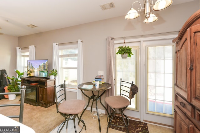 dining space featuring a chandelier and light carpet