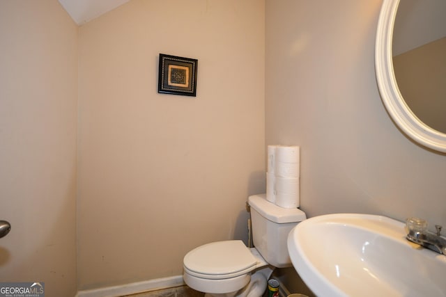 bathroom featuring vaulted ceiling, sink, and toilet