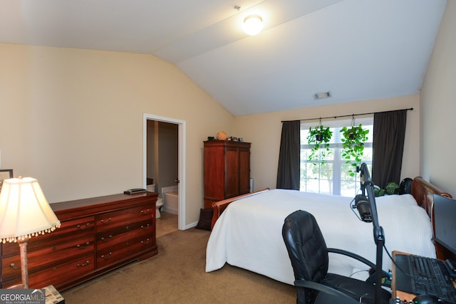 bedroom with lofted ceiling, carpet flooring, and connected bathroom