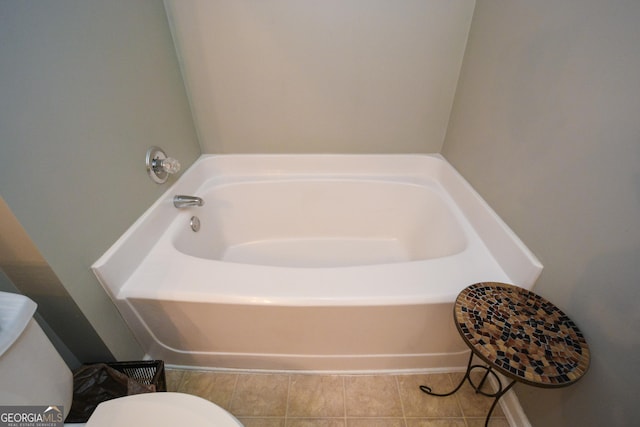 bathroom featuring tile patterned flooring, a bathing tub, and toilet