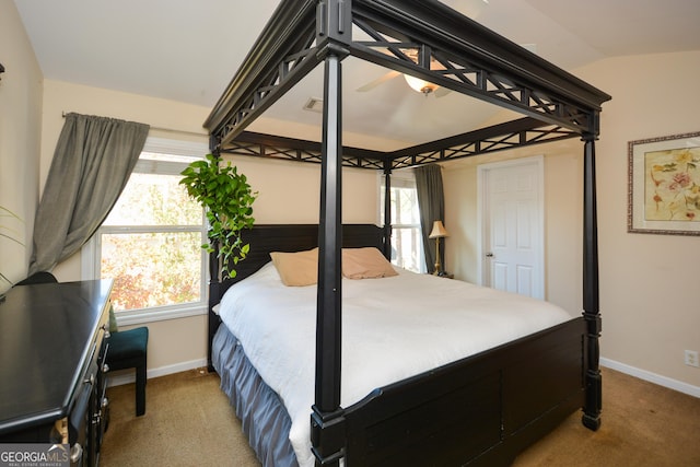 bedroom featuring multiple windows, vaulted ceiling, and carpet