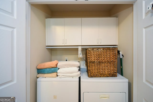 washroom featuring cabinets and washing machine and dryer