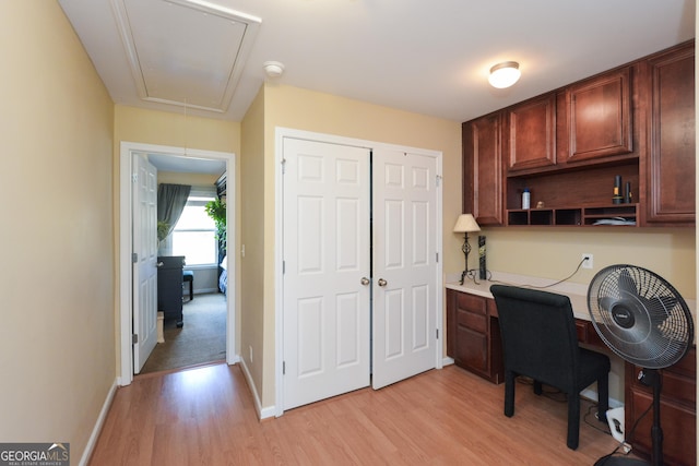 office space featuring built in desk and light hardwood / wood-style floors