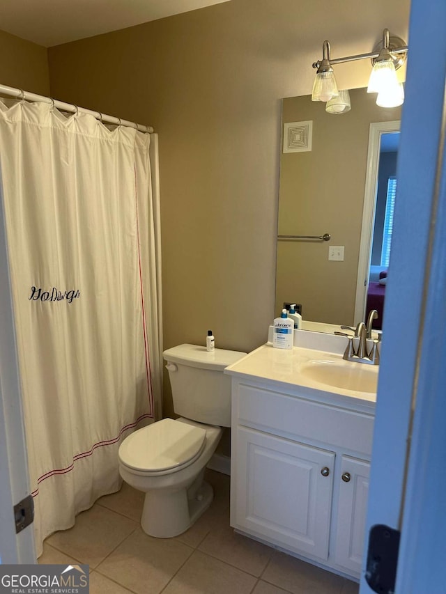 bathroom featuring tile patterned flooring, vanity, curtained shower, and toilet