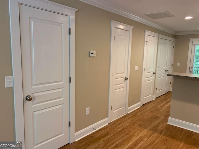 corridor featuring light hardwood / wood-style flooring and ornamental molding